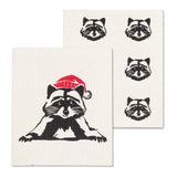 Two white towels with black raccoon illustrations, one wearing a red Santa hat.