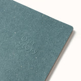 Teal notebook with 'Our Story' embossed on the cover