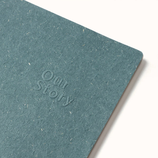 Teal notebook with 'Our Story' embossed on the cover