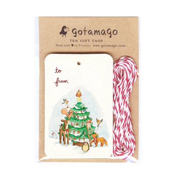 Gotamago ten gift tags set in a kraft paper package, featuring a sample white gift tag with a Christmas tree illustration, red and white bakers twine, and printed branding on a white background.