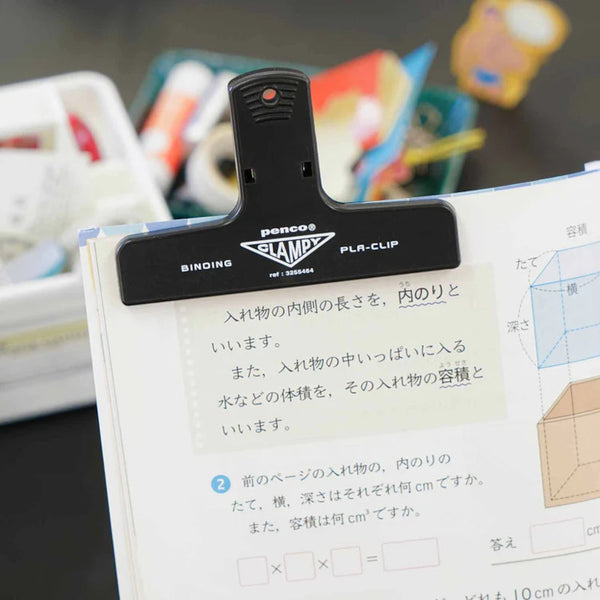 Black binding clamp on a book with a blurred background
