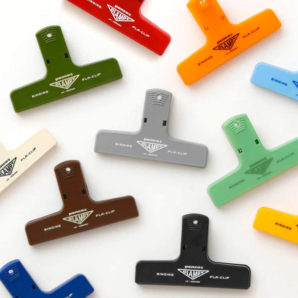 A collection of T-shaped plastic binder clips in various colors, including red, orange, green, blue, gray, brown, light green, black, cream, and yellow, arranged on a white background. Each clip features the 'BIRDS BONDING' brand logo and 'PLA-CLIP' printed on it.