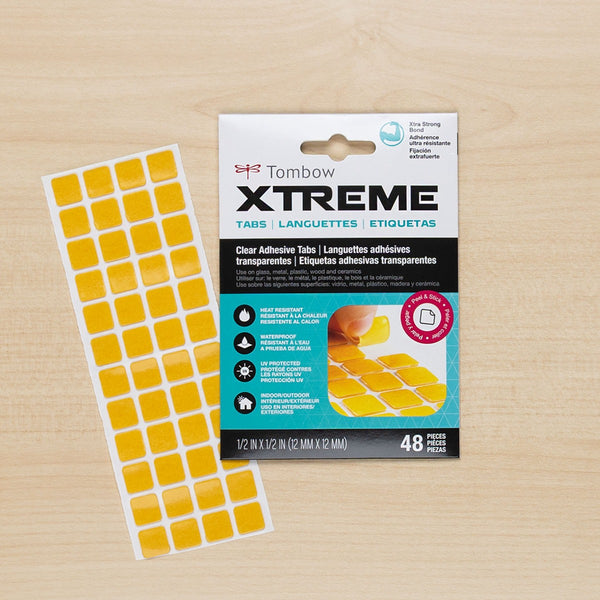 Tombow Xtreme adhesive tabs packaging with yellow tabs on a wooden surface